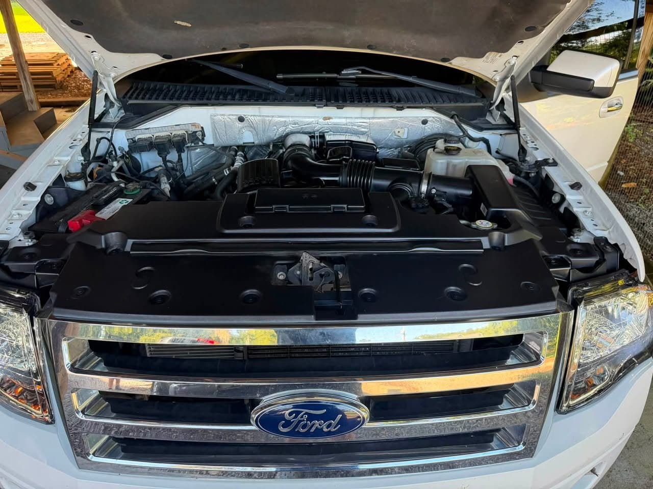 The same Ford Expedition engine bay after service, with the covers wiped back to black