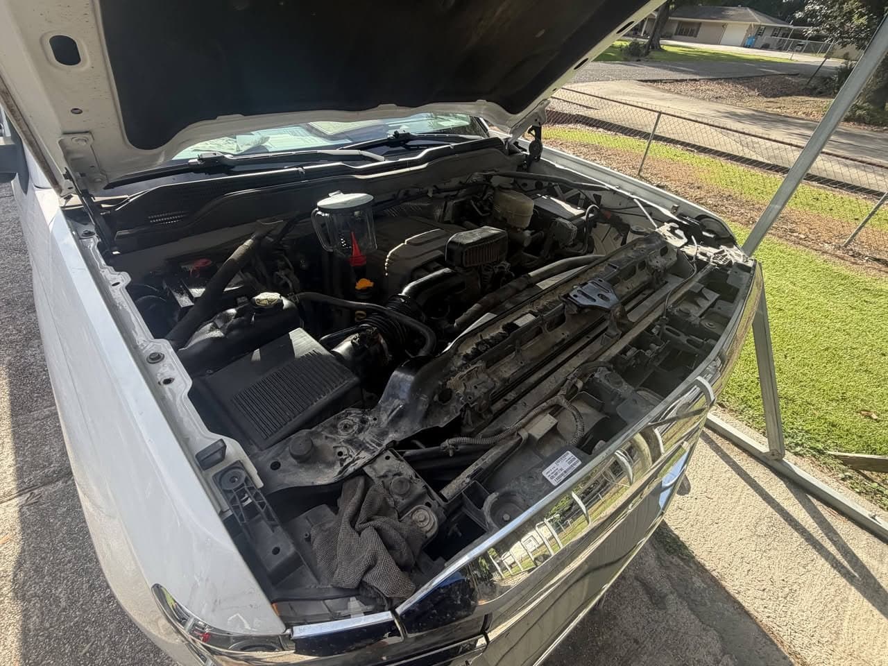 A pickup engine bay before service, dusty and faded across the intake and surrounding plastics