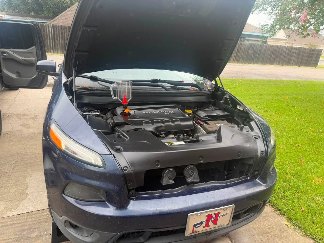 The same Jeep Cherokee engine bay after service, with the engine cover lettering legible again